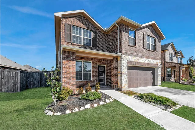 a front view of a house with a garden and yard