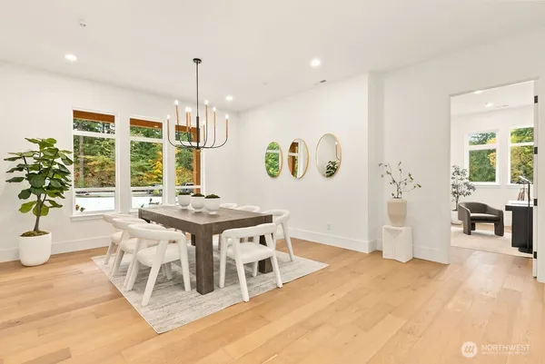 a open kitchen with stainless steel appliances kitchen island granite countertop a stove a refrigerator a sink a dining table and chairs with wooden floor