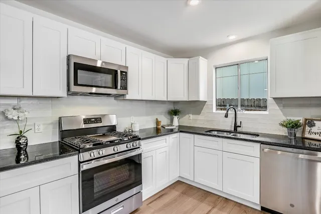 a kitchen with cabinets stainless steel appliances a sink and a counter space