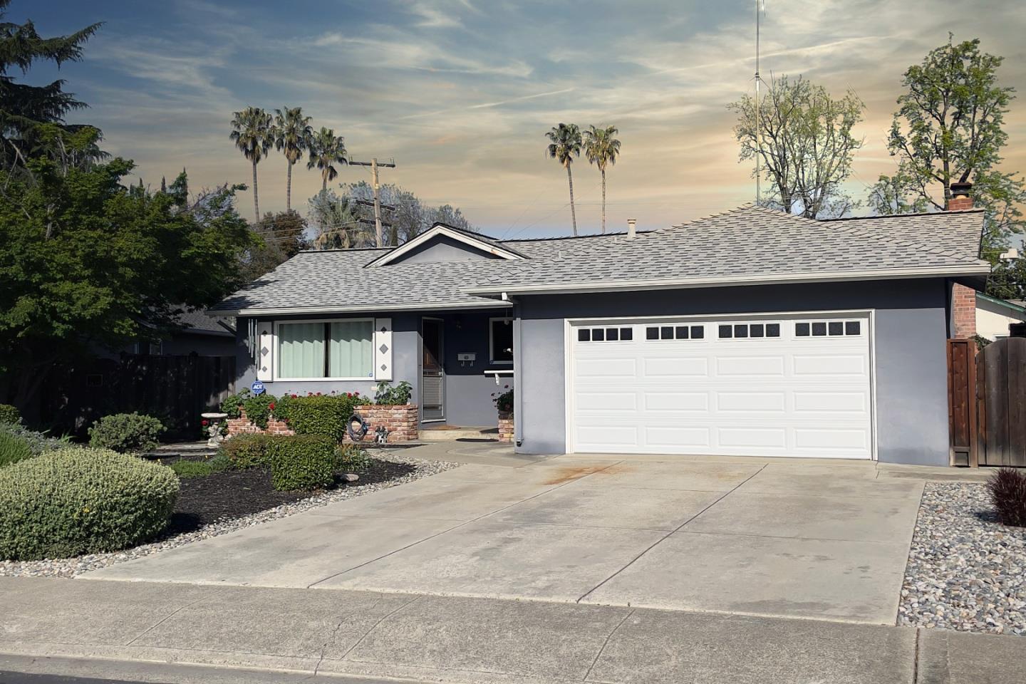 a front view of a house with a garden and garage