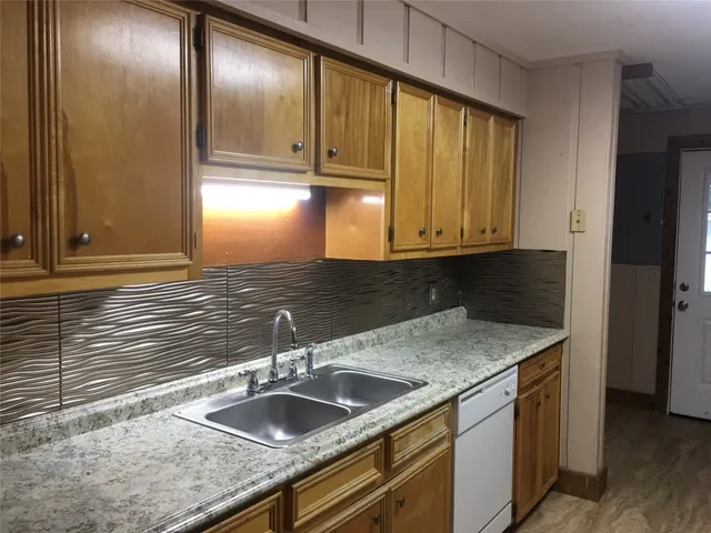 a kitchen with a sink and a wooden cabinets