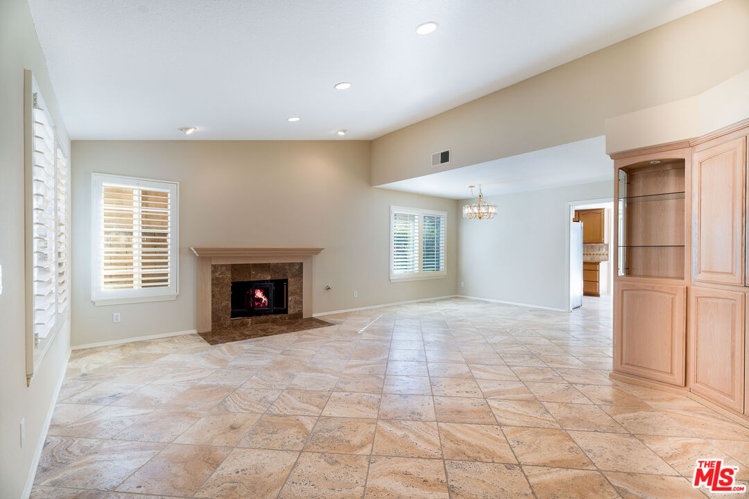 19762 Turtle Springs Way Porter Ranch, CA 91326 - Photo 3 of 52 a view of an empty room with a fireplace and a window