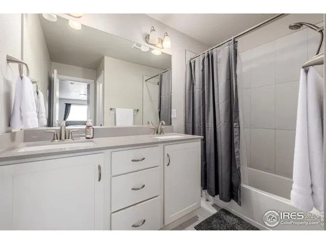 a bathroom with a double vanity sink mirror and shower