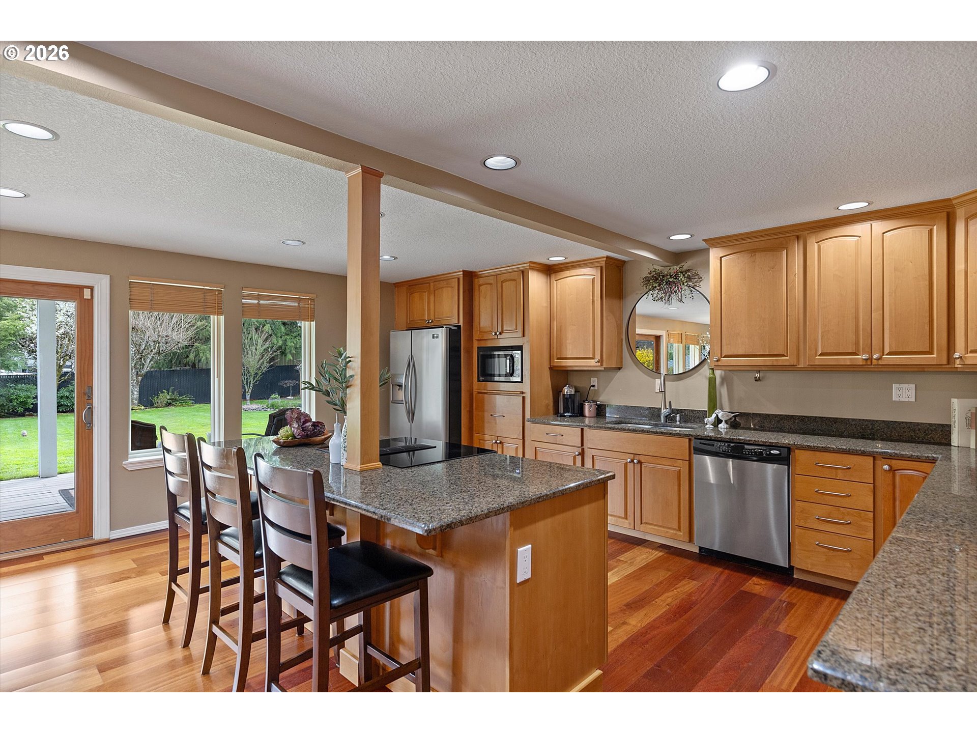 10540 Southwest Errol Street Tigard, OR 97223 - Photo 8 of 47 a kitchen with stainless steel appliances granite countertop table chairs and a large window