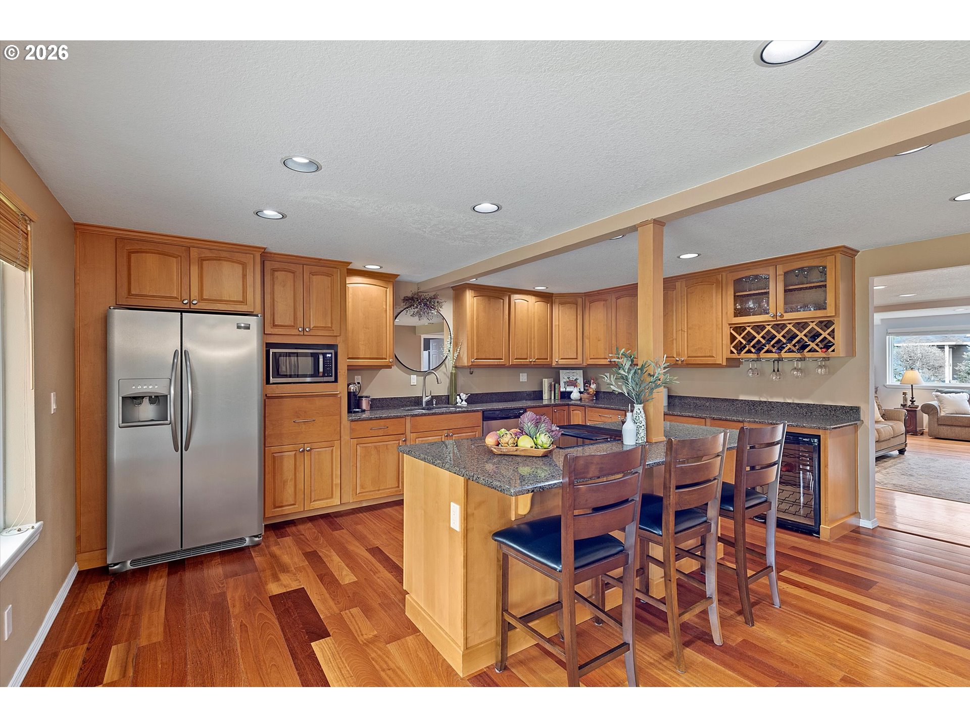 10540 Southwest Errol Street Tigard, OR 97223 - Photo 10 of 47 a kitchen with stainless steel appliances a refrigerator a stove a sink and a dining table with wooden floor