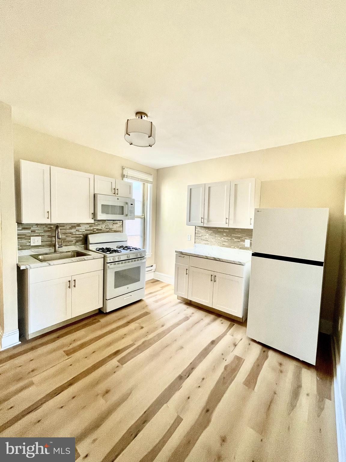3151 G Street Philadelphia, PA 19134 - Photo 15 of 16 a kitchen with white cabinets and white appliances