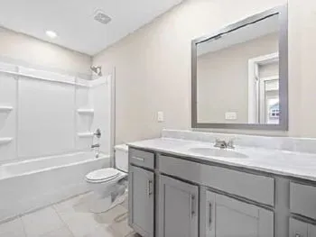 a bathroom with a granite countertop sink toilet a large mirror a shower and bathtub