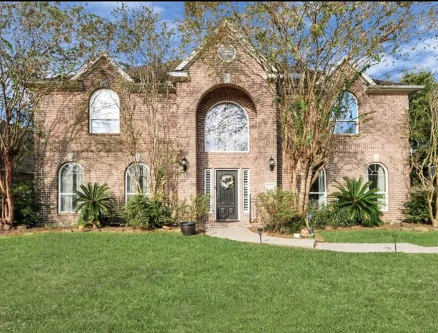 a large stone house with a big yard and potted plants