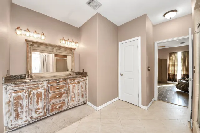 a spacious bathroom with a tub a double vanity sink and a mirror