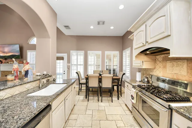 a kitchen with granite countertop a sink and a stove