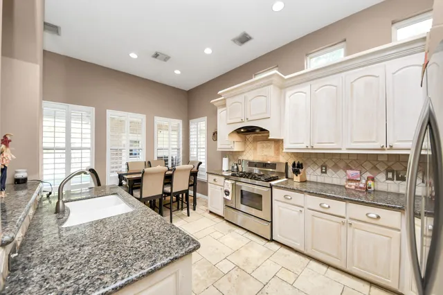 a kitchen with white cabinets and sink