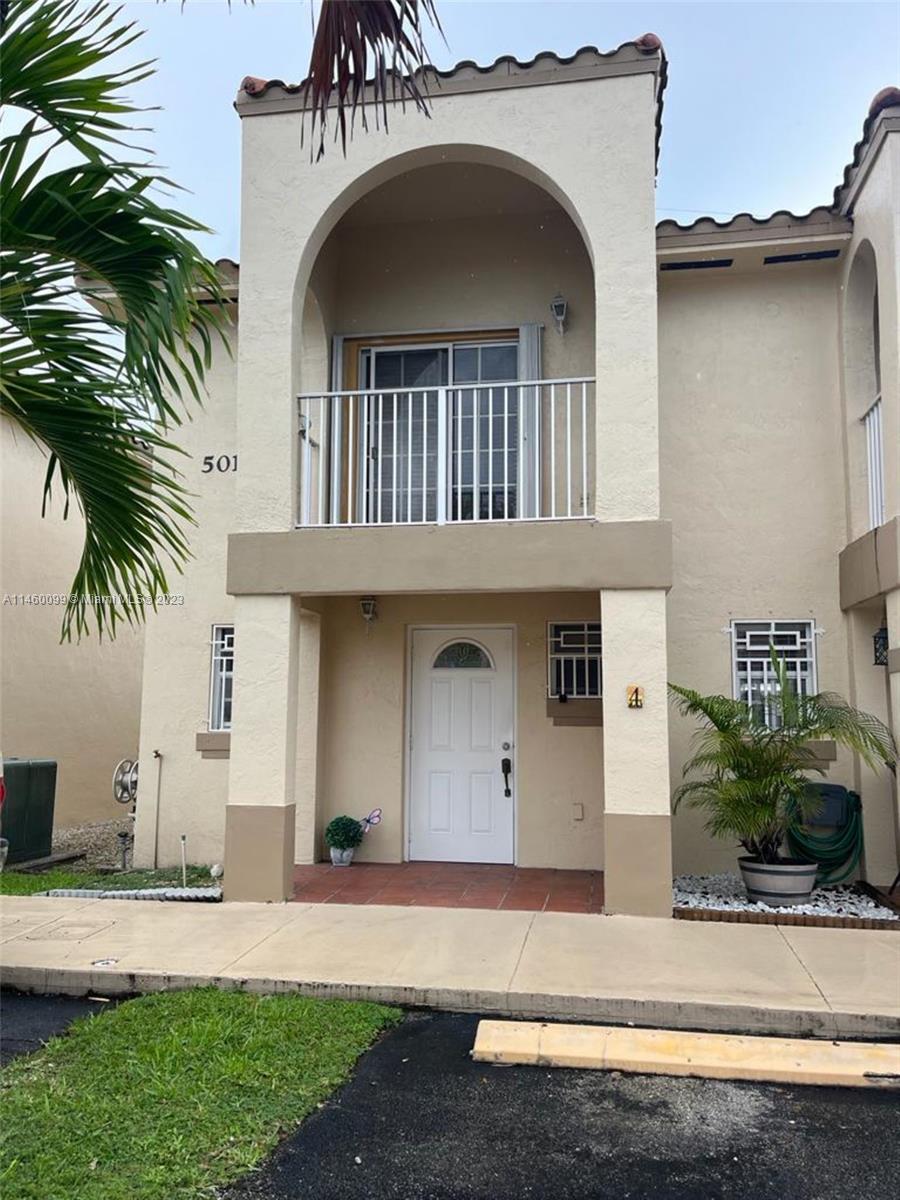 501 West 68th Street, Unit 4 Hialeah, FL 33014 - Photo 2 of 20 a front view of a house with a yard and garage