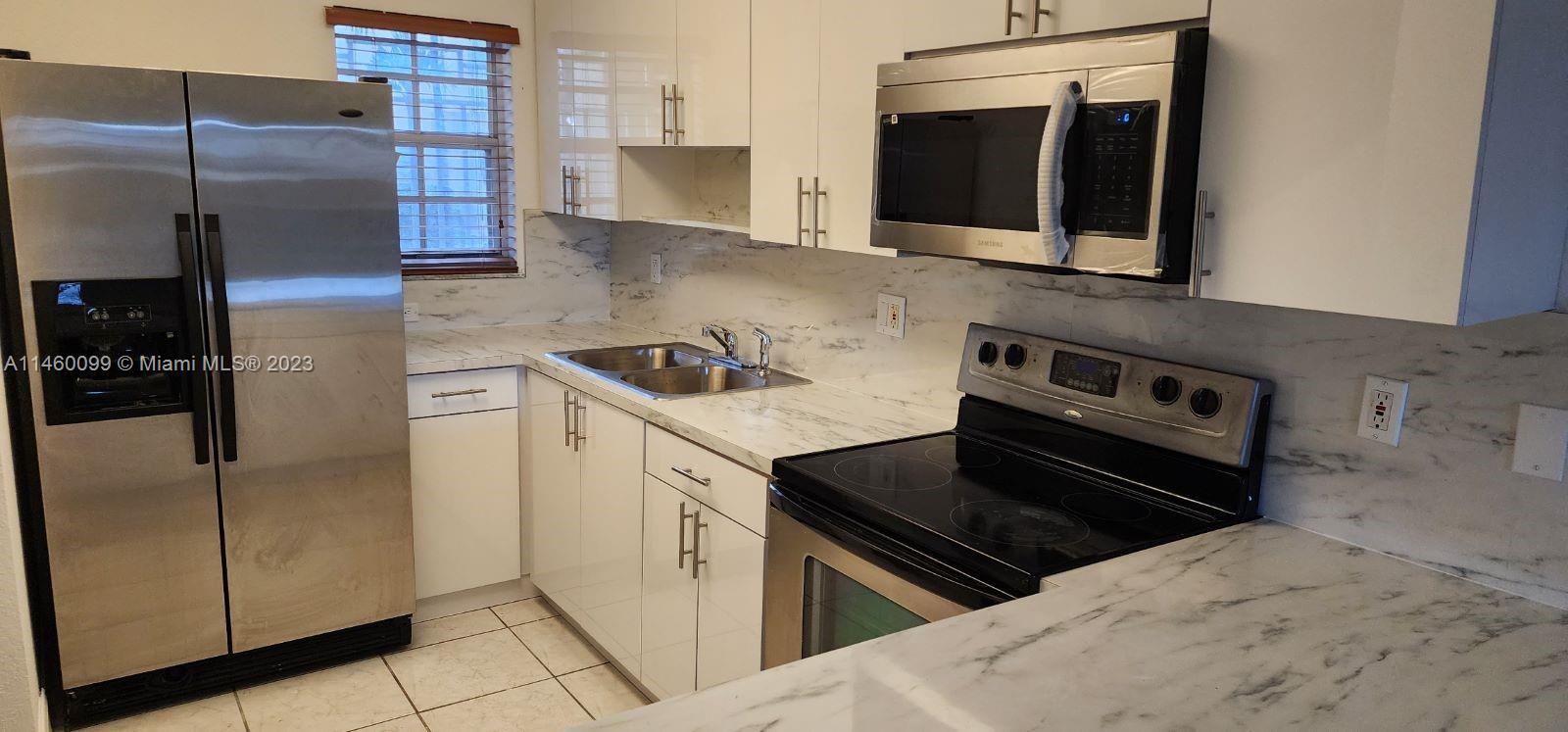 501 West 68th Street, Unit 4 Hialeah, FL 33014 - Photo 4 of 20 a kitchen with a refrigerator stove and microwave