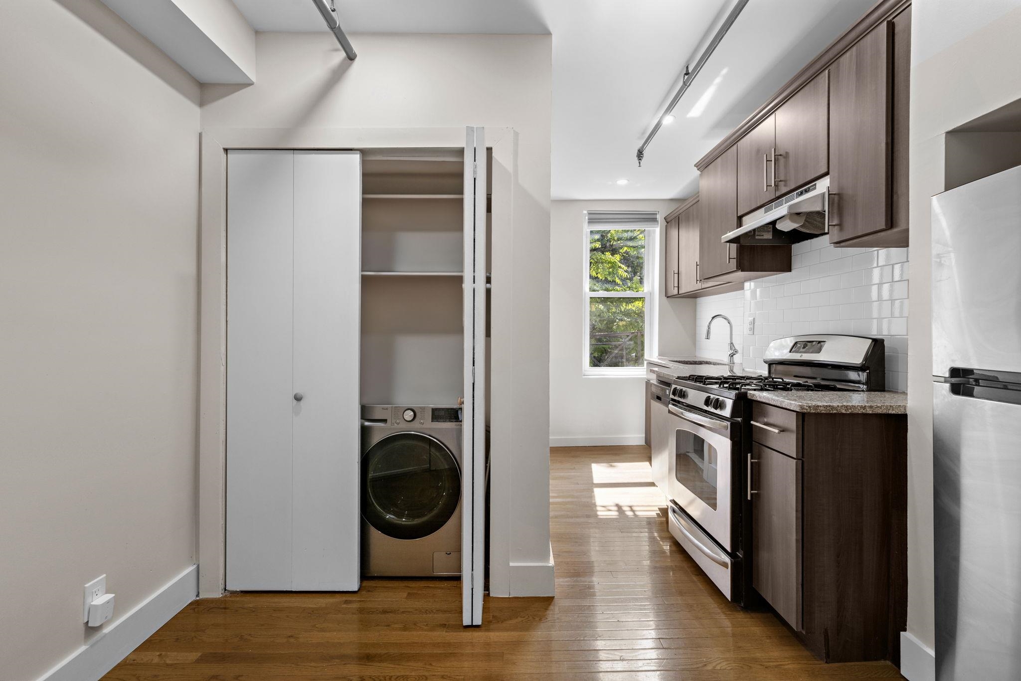309 Monroe Street, Unit FIVE Hoboken, NJ 07030 - Photo 8 of 14 a kitchen with stainless steel appliances granite countertop a stove a refrigerator and a wooden floors