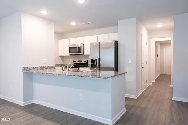 a kitchen with stainless steel appliances granite countertop a stove a sink and a refrigerator