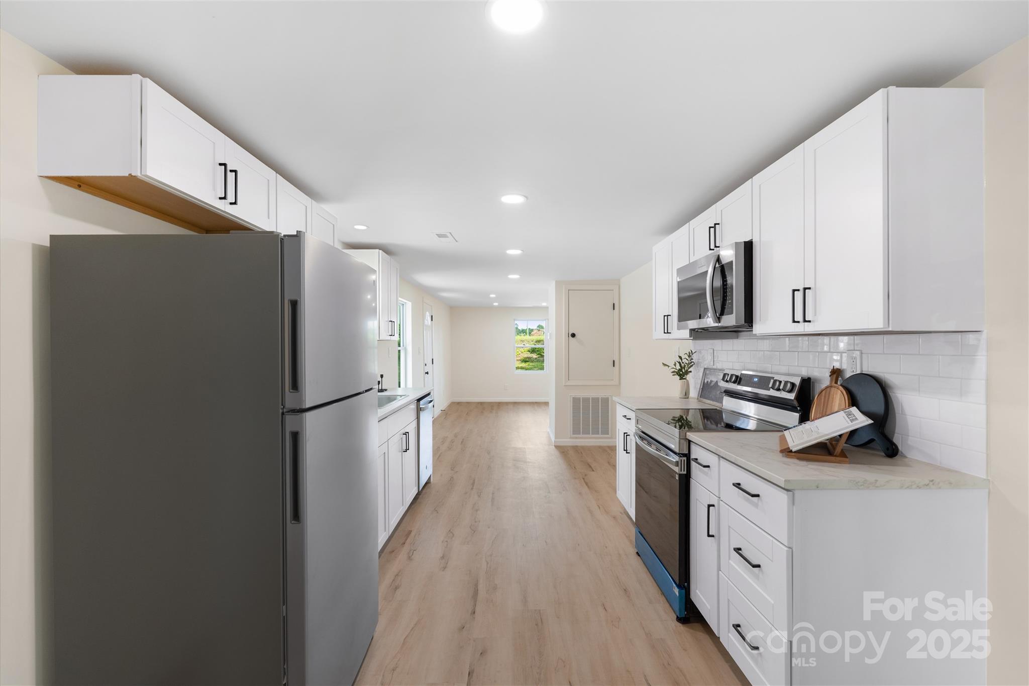 1574 Mangum Drive Lancaster, SC 29720 - Photo 8 of 22 a kitchen with stainless steel appliances a refrigerator a sink a stove and white cabinets