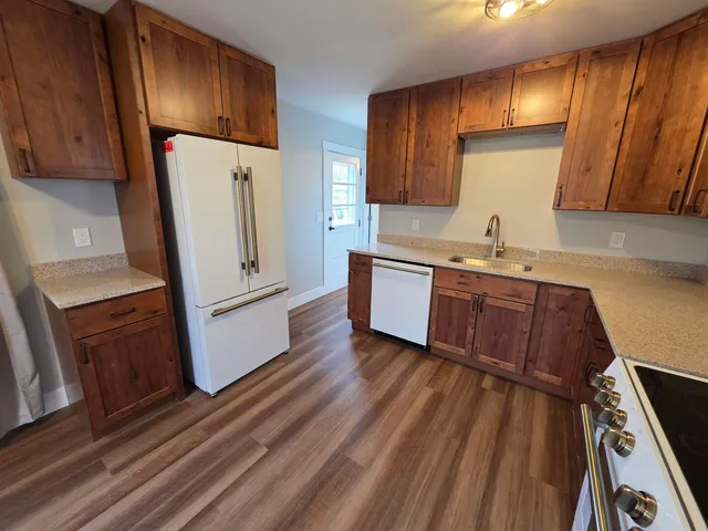 a kitchen with wooden floors and white appliances