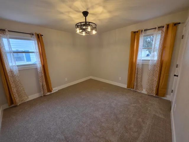 an empty room with chandelier fan