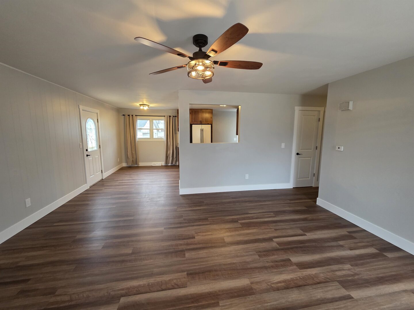 1206 10th Avenue North Clinton, IA 52732 - Photo 5 of 27 a view of a livingroom with wooden floor a ceiling fan and windows