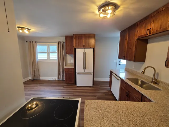 a kitchen with stainless steel appliances granite countertop a sink stove and refrigerator