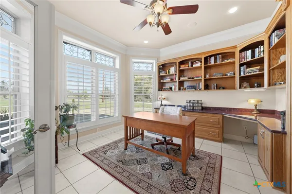a living room with furniture a flat screen tv and floor to ceiling window