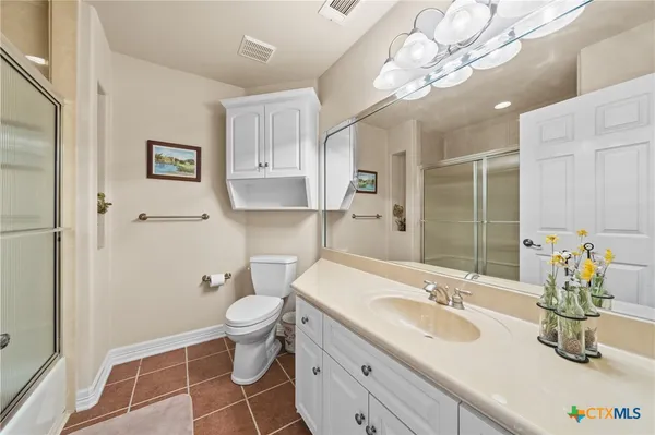 a spacious bedroom with a bed and a chandelier