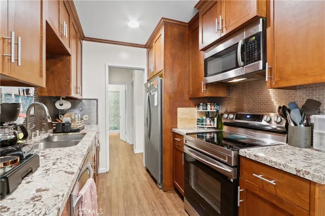 a kitchen with stainless steel appliances granite countertop a stove microwave and sink