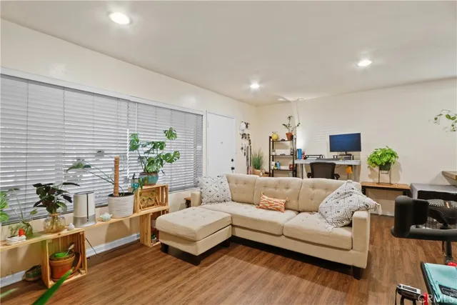a living room with furniture a flat screen tv and a potted plant