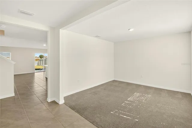 a kitchen with stainless steel appliances granite countertop a stove top oven a sink a dining table and chairs with wooden floor