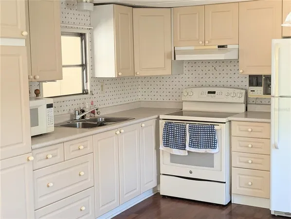 a kitchen with cabinets appliances and a window