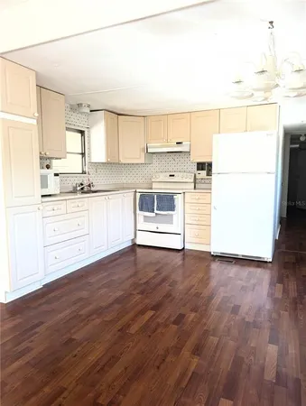 a kitchen with wooden floors and white appliances