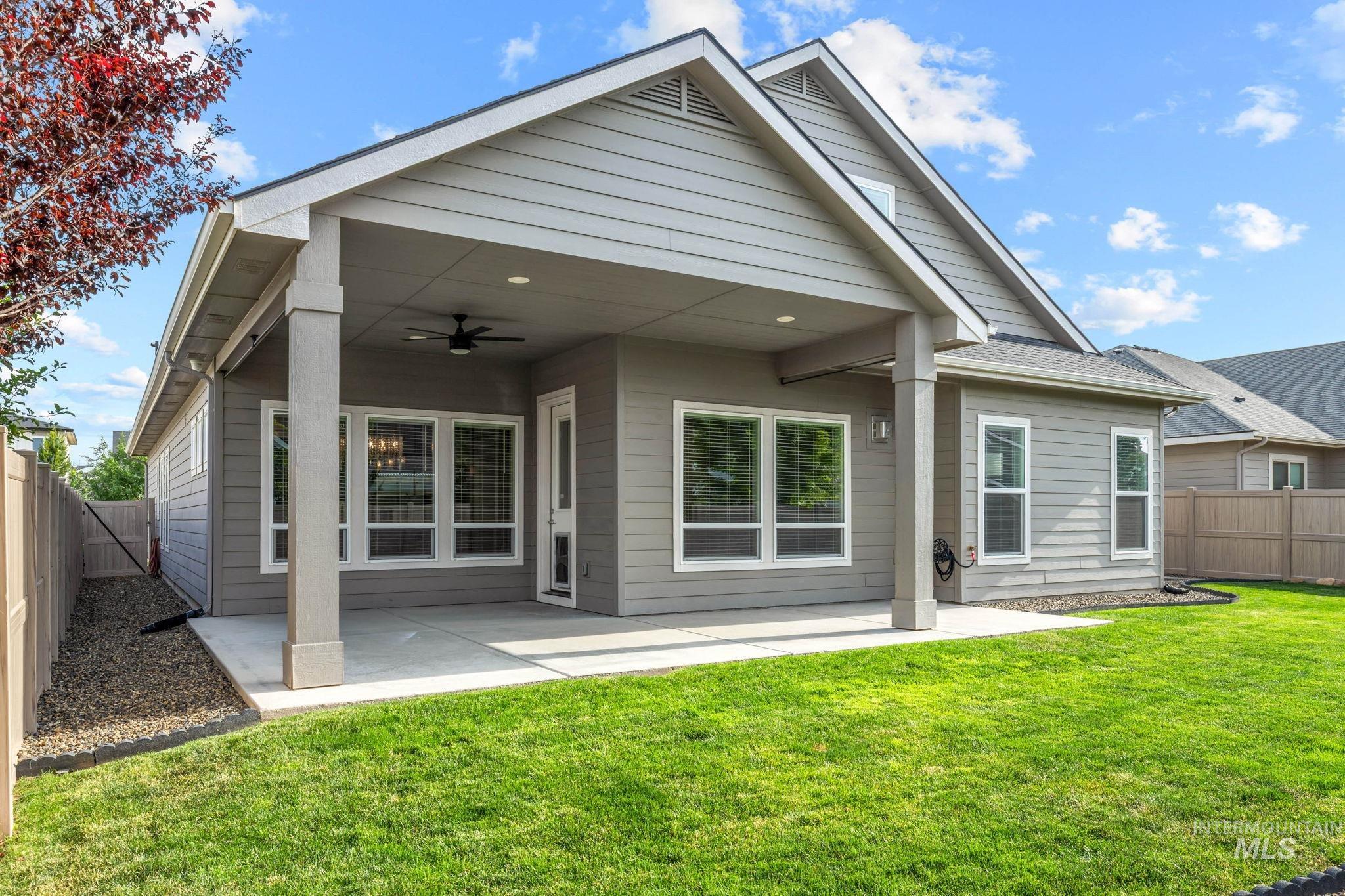 2934 East Murchison Street Meridian, ID 83642 - Photo 39 of 44 Expansive backyard featuring a concrete patio with a covered section, an outdoor ceiling fan, and a manicured lawn