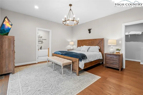 a bedroom with a bed and a chandelier