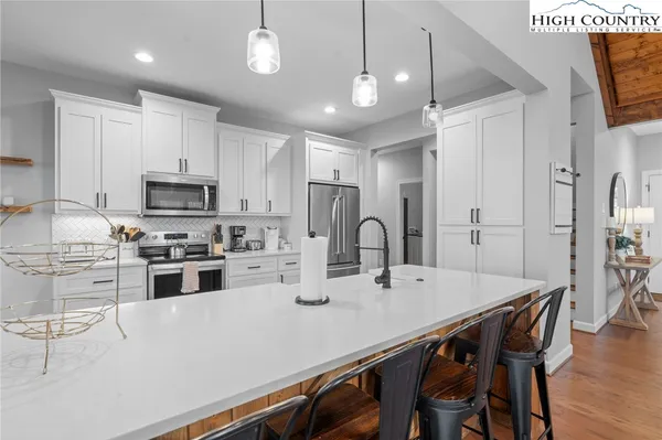 a large white kitchen with stainless steel appliances granite countertop lots of counter top space