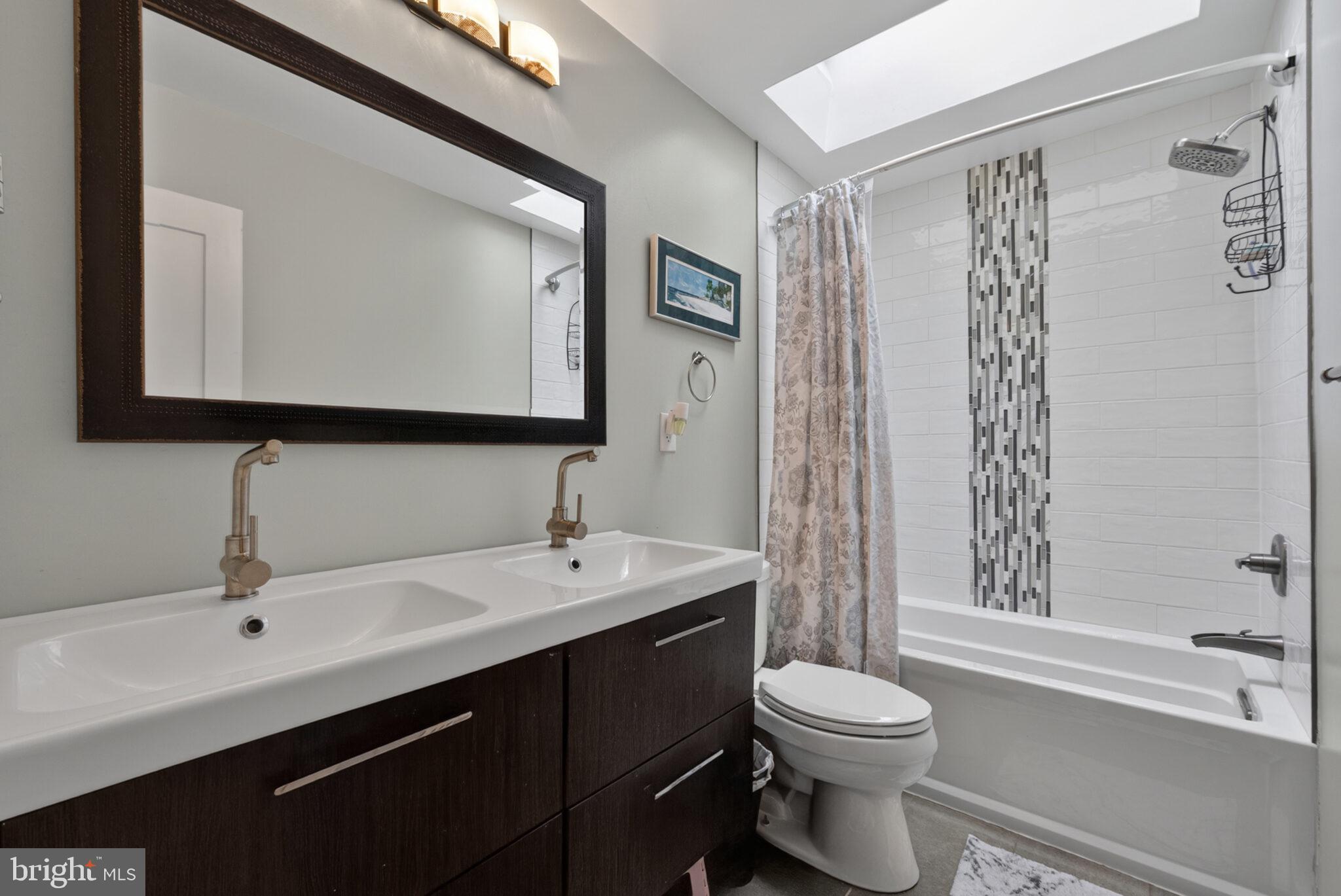 5939 Craft Alexandria, VA 22310 - Photo 16 of 54 a bathroom with a double vanity sink toilet mirror and shower