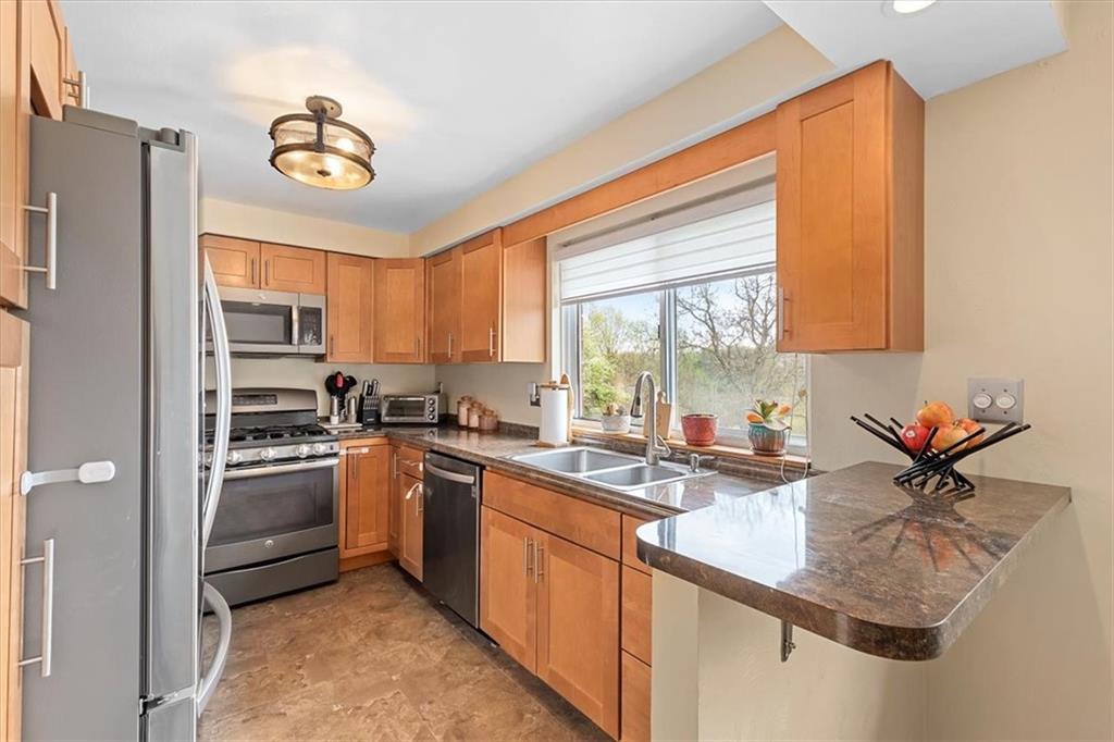 666 Lindsay Road Carnegie, PA 15106 - Photo 8 of 25 a kitchen with stainless steel appliances granite countertop a sink stove and refrigerator