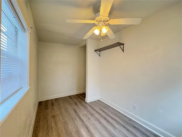 a view of a room with wooden floor and fan