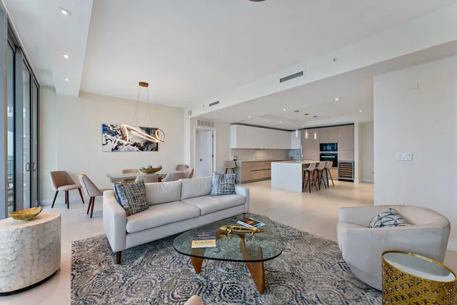 a living room with furniture kitchen view and a table