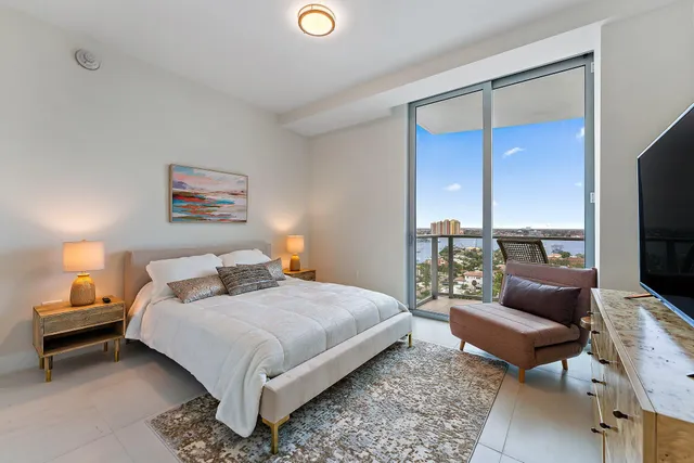 a bedroom with a bed couch and a flat screen tv