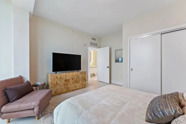 a bedroom with a bed and a television