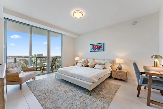 a bedroom with a bed and large windows