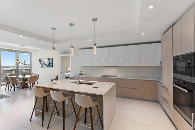 a kitchen with a sink and chairs