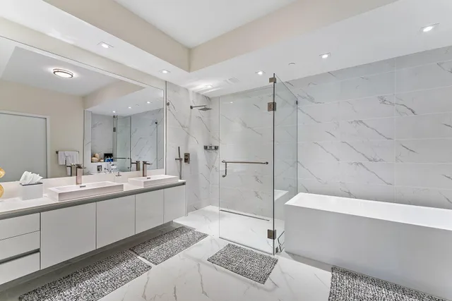 a bathroom with a double vanity sink toilet mirror bathtub and shower