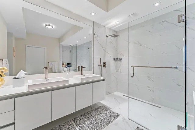 a bathroom with a double vanity sink mirror and shower