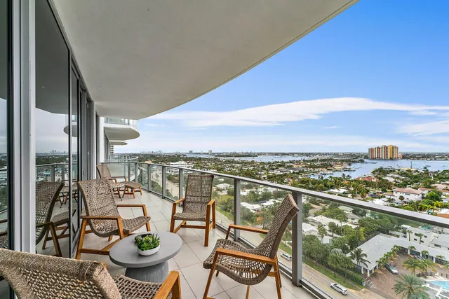 a view of a balcony with chairs and a potted plant