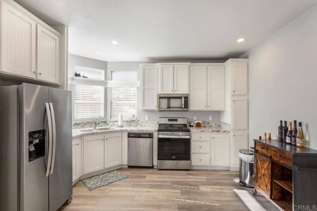 3505 Alpine Boulevard, Unit 15 Alpine, CA 91901 - Photo 10 of 23 a kitchen with stainless steel appliances granite countertop a stove top oven a refrigerator a sink and dishwasher with white cabinets