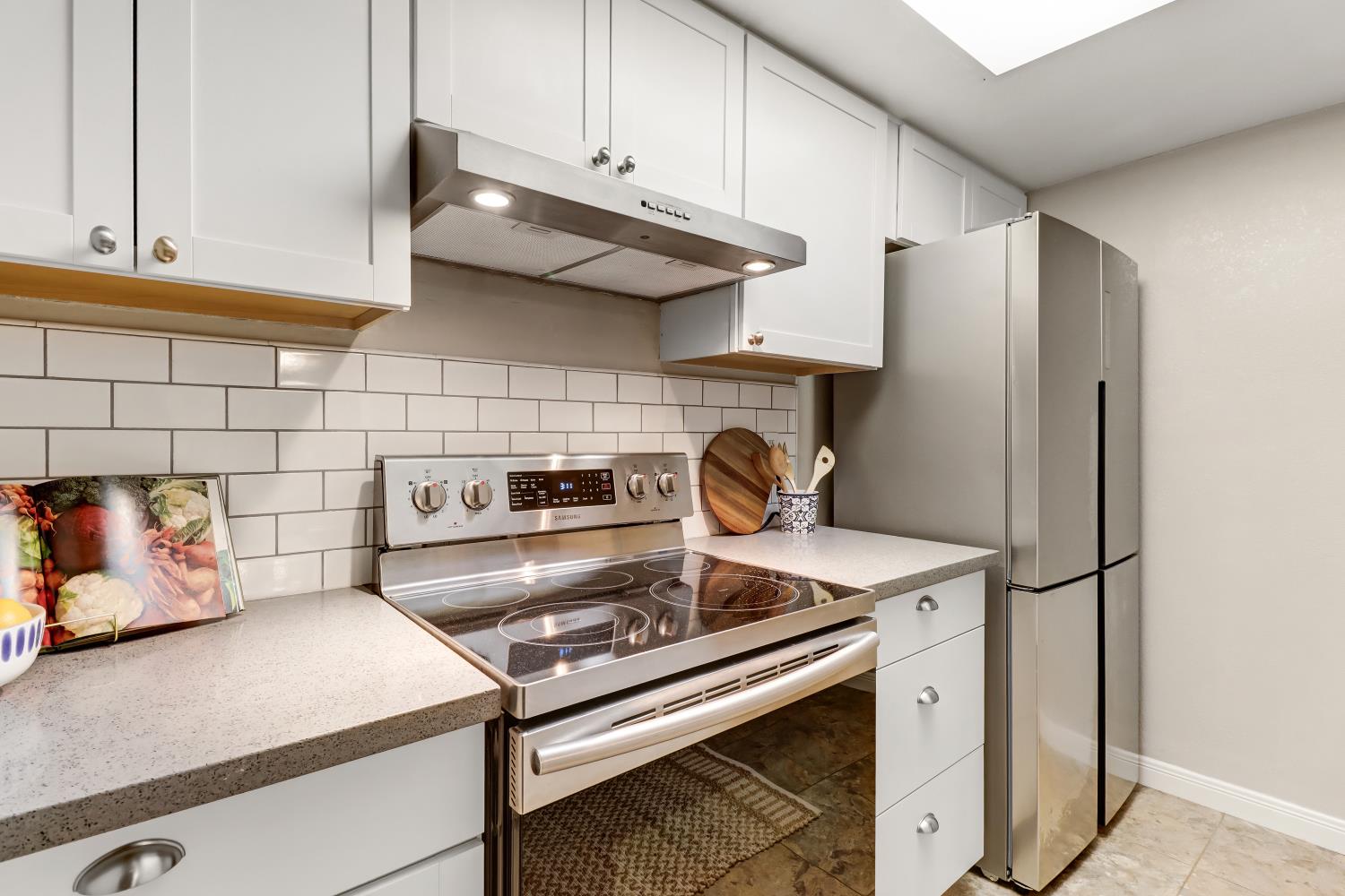 2317 East 8th Street Davis, CA 95618 - Photo 20 of 42 a kitchen with stainless steel appliances granite countertop a sink stove and refrigerator