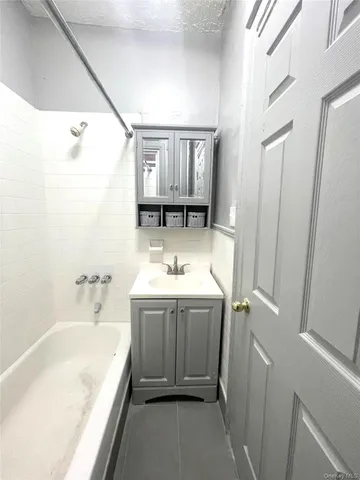 a bathroom with a tub sink and mirror