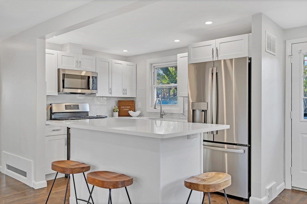 9 Cutter Road Boston, MA 02132 - Photo 8 of 17 a kitchen with stainless steel appliances a refrigerator a stove a sink and chairs