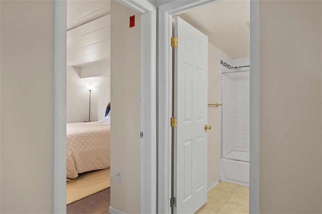 5 Bayard Road, Unit 121 Pittsburgh, PA 15213 - Photo 15 of 24 Adjacent to the bedroom is the bathroom, which is accessible through an open doorway. The layout makes the transition between the two spaces seamless, providing both privacy and convenience.